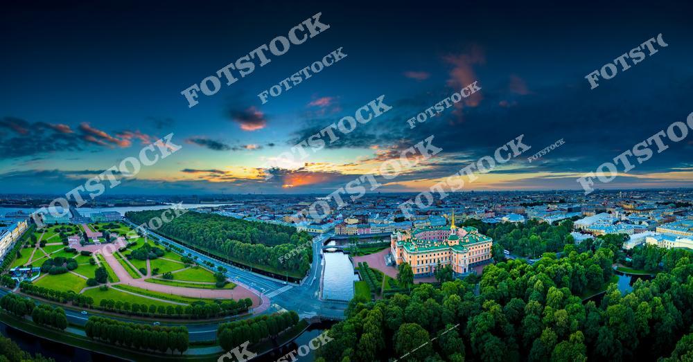 Панорамная фотография центра Санкт-Петербурга с высоты птичьего полета. На снимке видны Марсово поле, Инженерный замок, улицы исторического центра и архитектурные ансамбли города. Съемка с дрона позволяет увидеть масштабы городской застройки, панорамные виды улиц и архитектуру Северной столицы России. Фотография передает атмосферу исторического Петербурга, красоту культурных и архитектурных объектов, гармонию городских улиц и открытых площадей. Снимок идеально подходит для туристических публикаций, фотостоков, рекламы, оформления интерьеров и материалов о достопримечательностях Санкт-Петербурга.